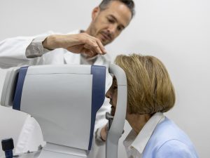 A patient puts her head inside a high street optometry scanner