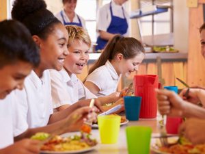 Image shows school children having lunch
